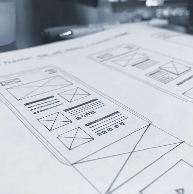 Closeup view of hand-drawn wireframes on a phone template sketch pad